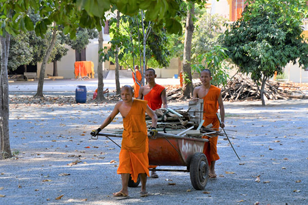 カンボジアの若い僧侶。割った薪はリヤカーで倉庫へ